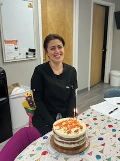 Associate sitting in front of a birthday cake